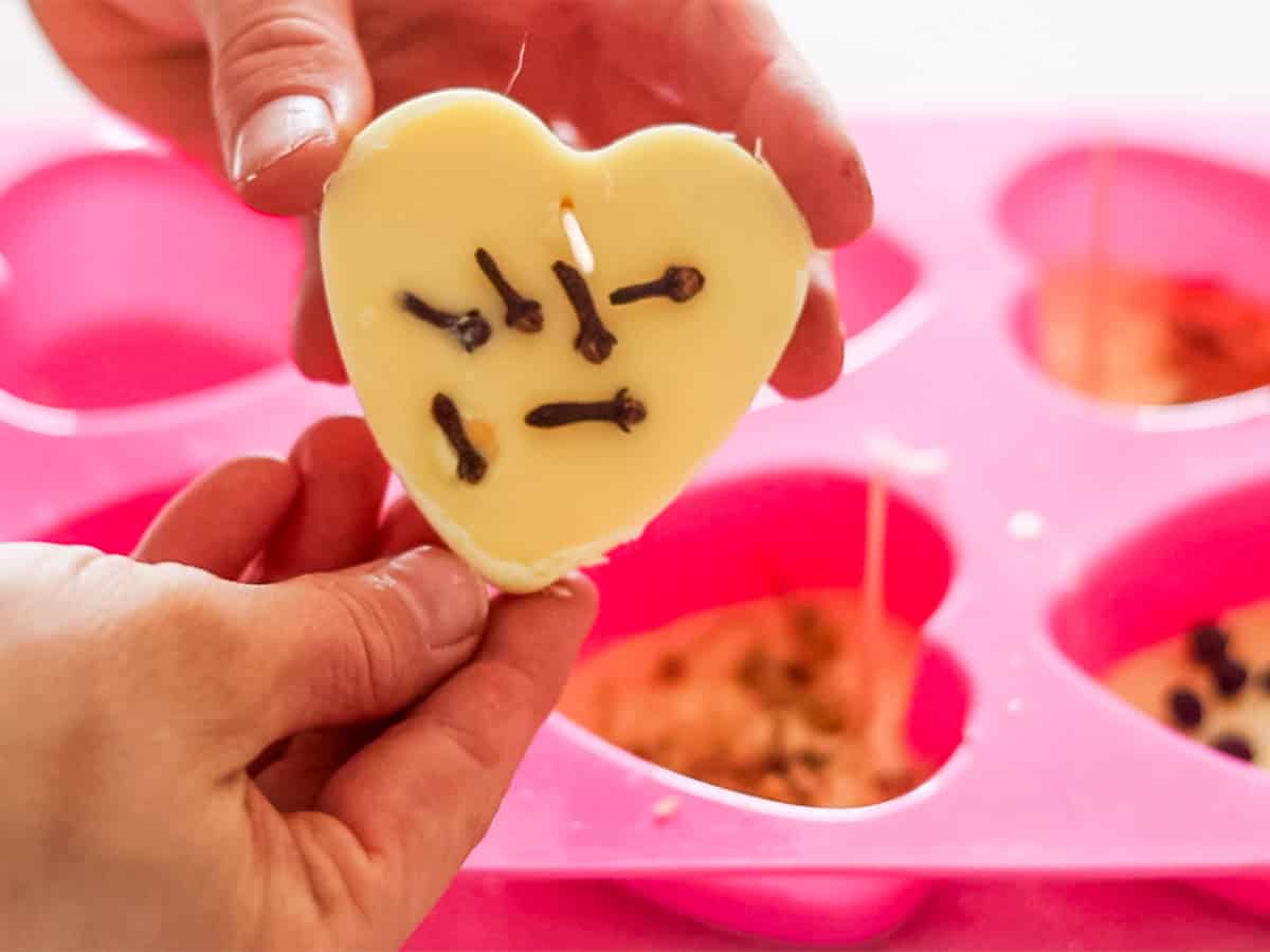 Popping wax air fresheners out of silicone heart molds.