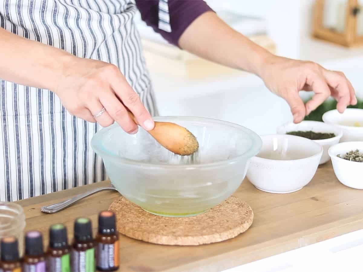 Adding herbs to a bowl of olive oil.