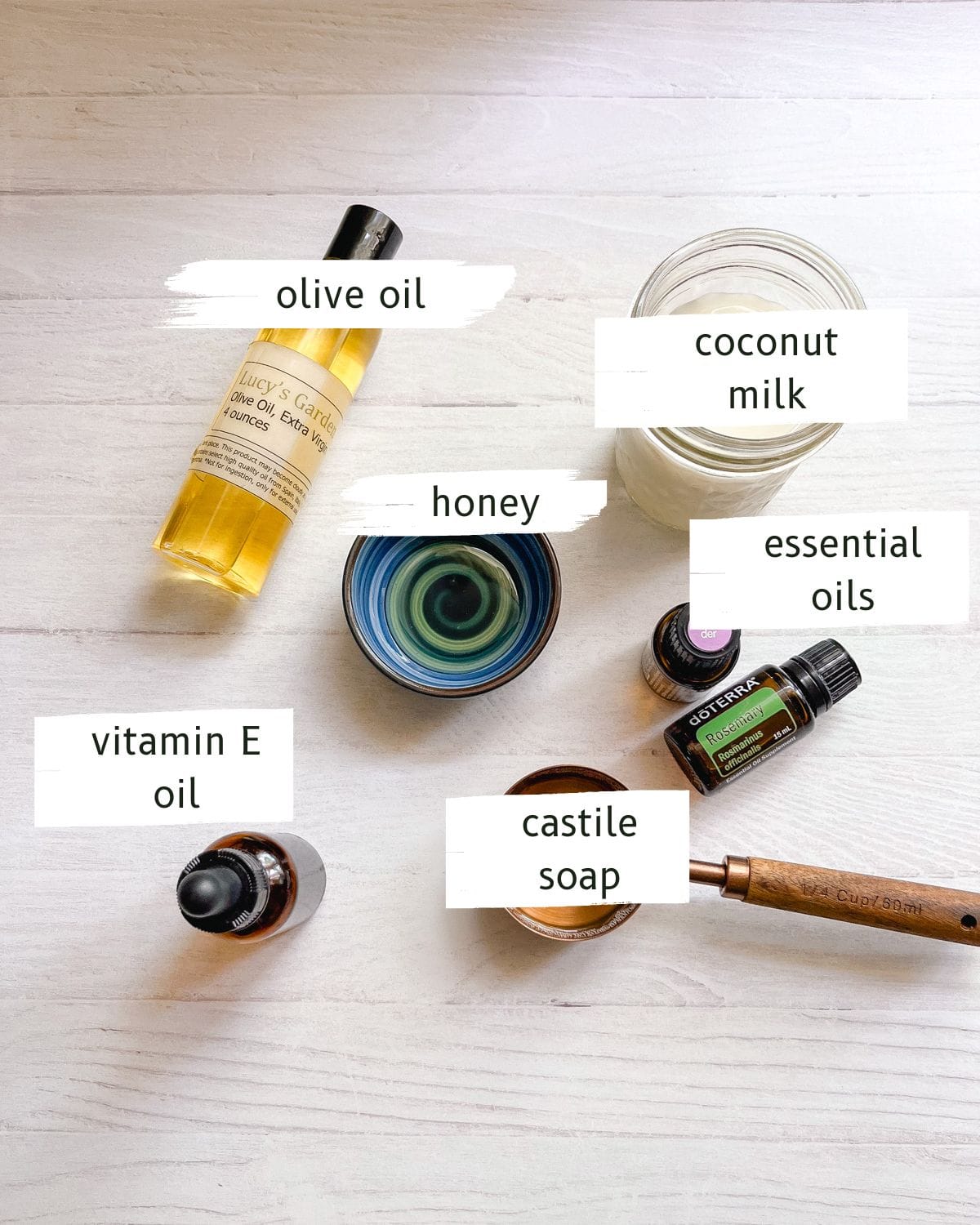 Homemade rosemary shampoo ingredients labeled on a white table.