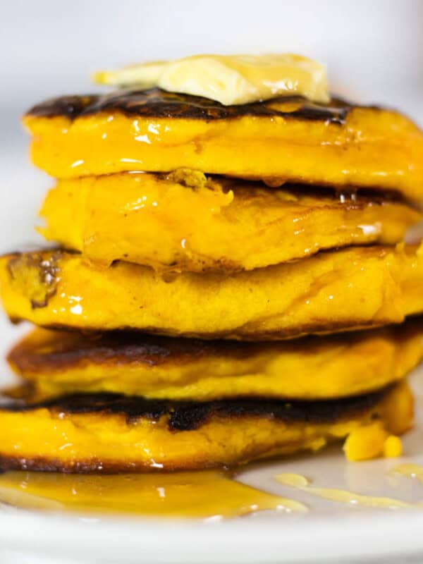 A stack of healthy pumpkin pancakes with butter on top.