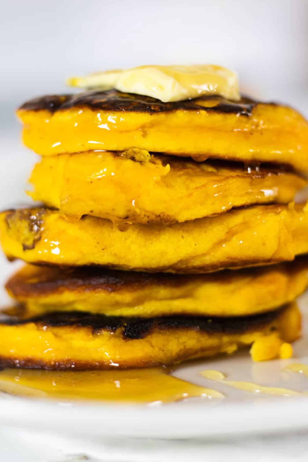 A stack of healthy pumpkin pancakes with butter on top.