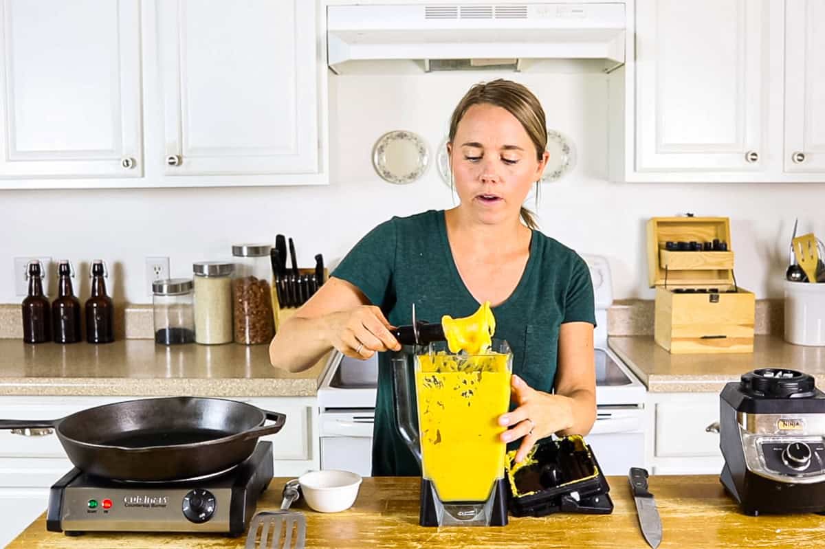 Scooping pumpkin pancake batter out of a blender. 