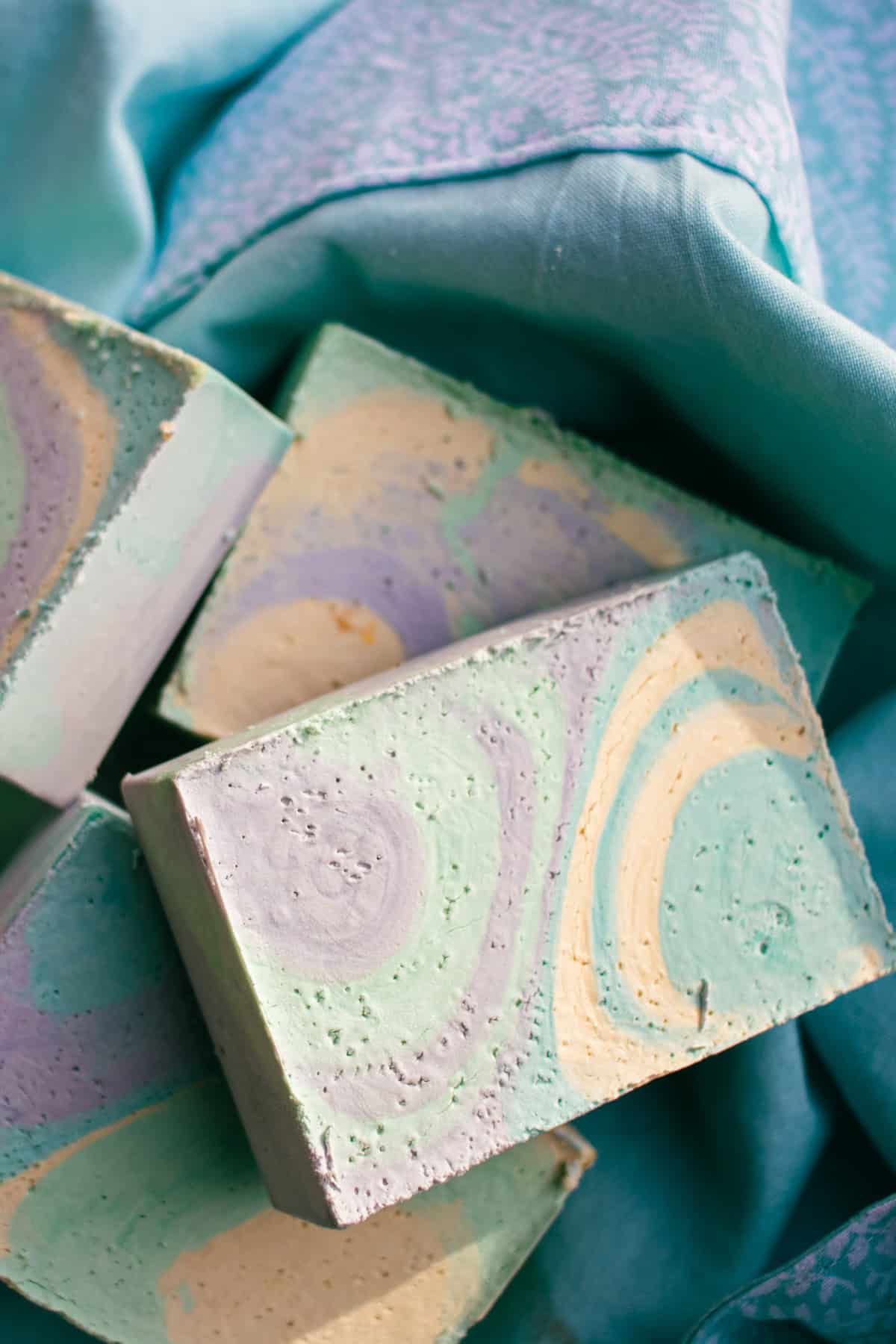Colorful olive oil soap bars on a blue towel.