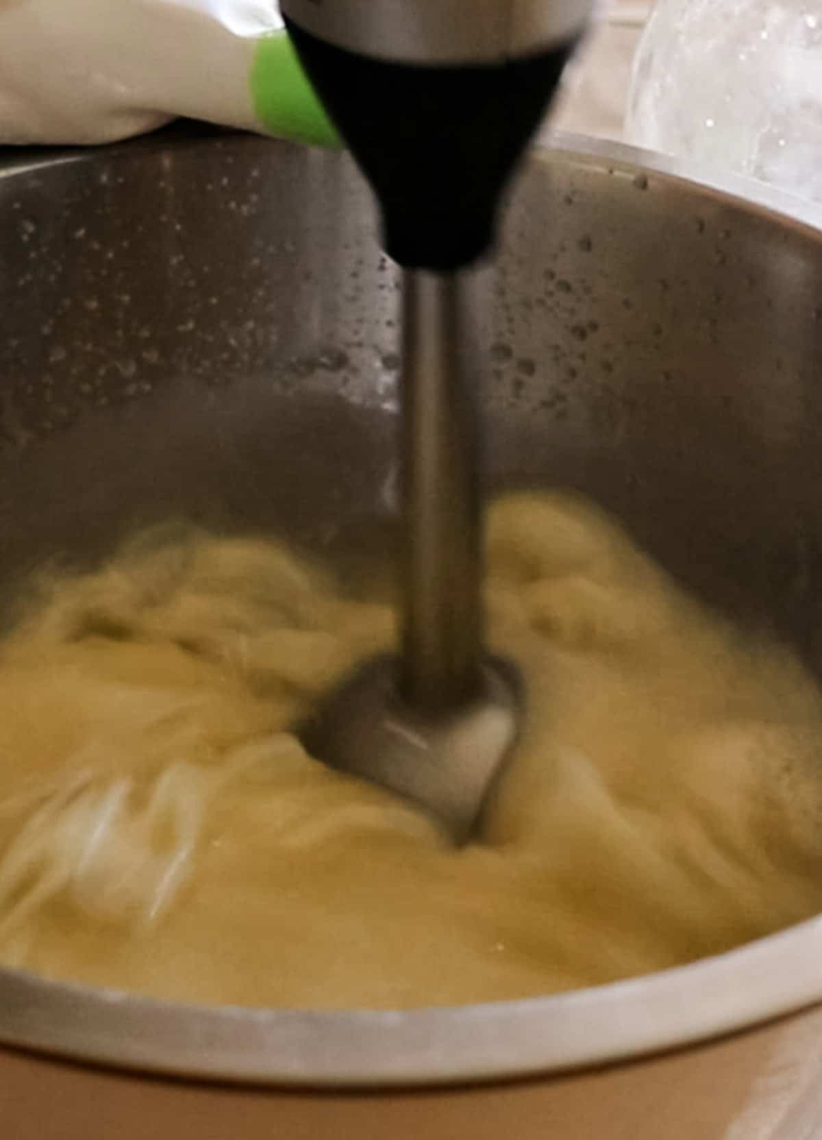 Mixing soap mixture with an immersion blender.