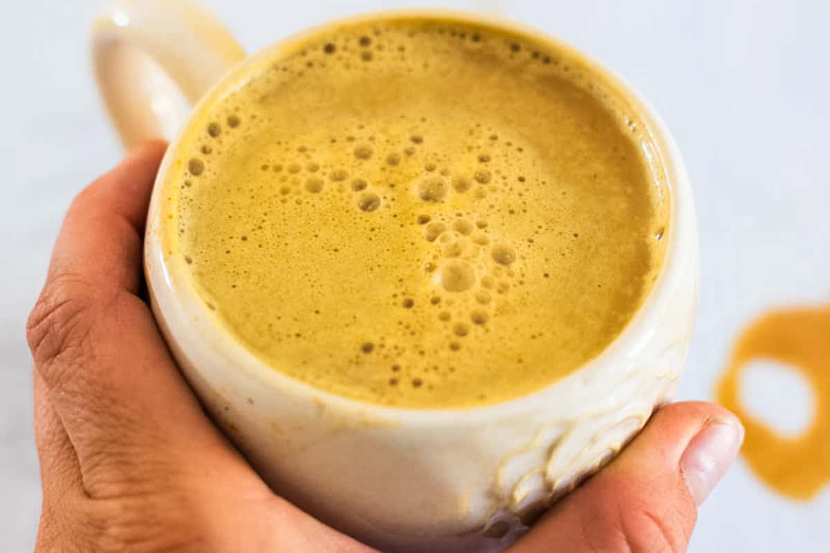 Holding a mug of pumpkin spice latte.