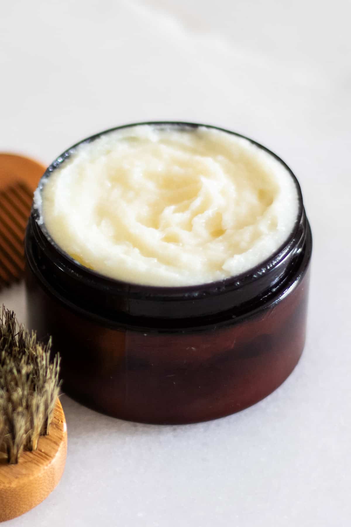 Beard conditioning balm in an amber jar.