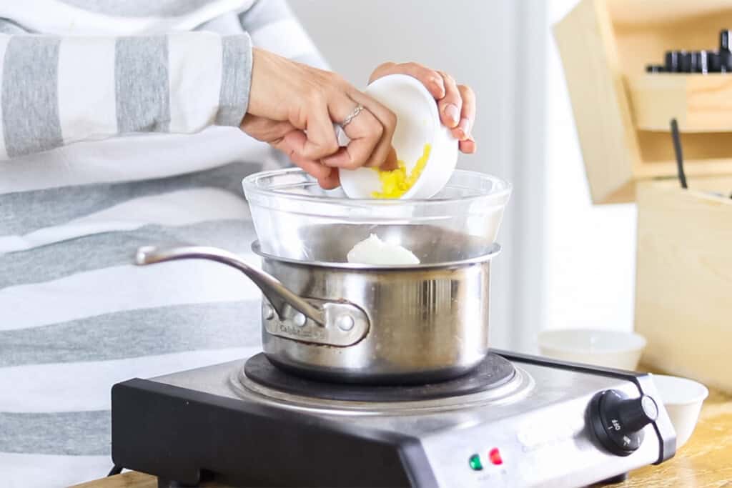 Pouring ingredients into a double boiler. 