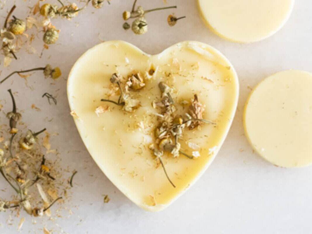 A heart-shaped wax air freshener next to dried florals and other wax air fresheners.