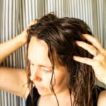 Massaging baking soda hair rinse into the hair.