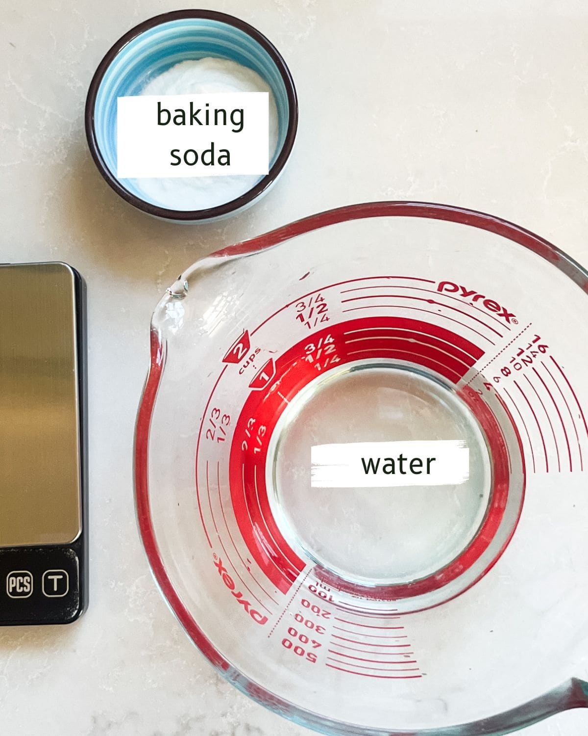 Baking soda hair rinse ingredients labeled on a kitchen counter.