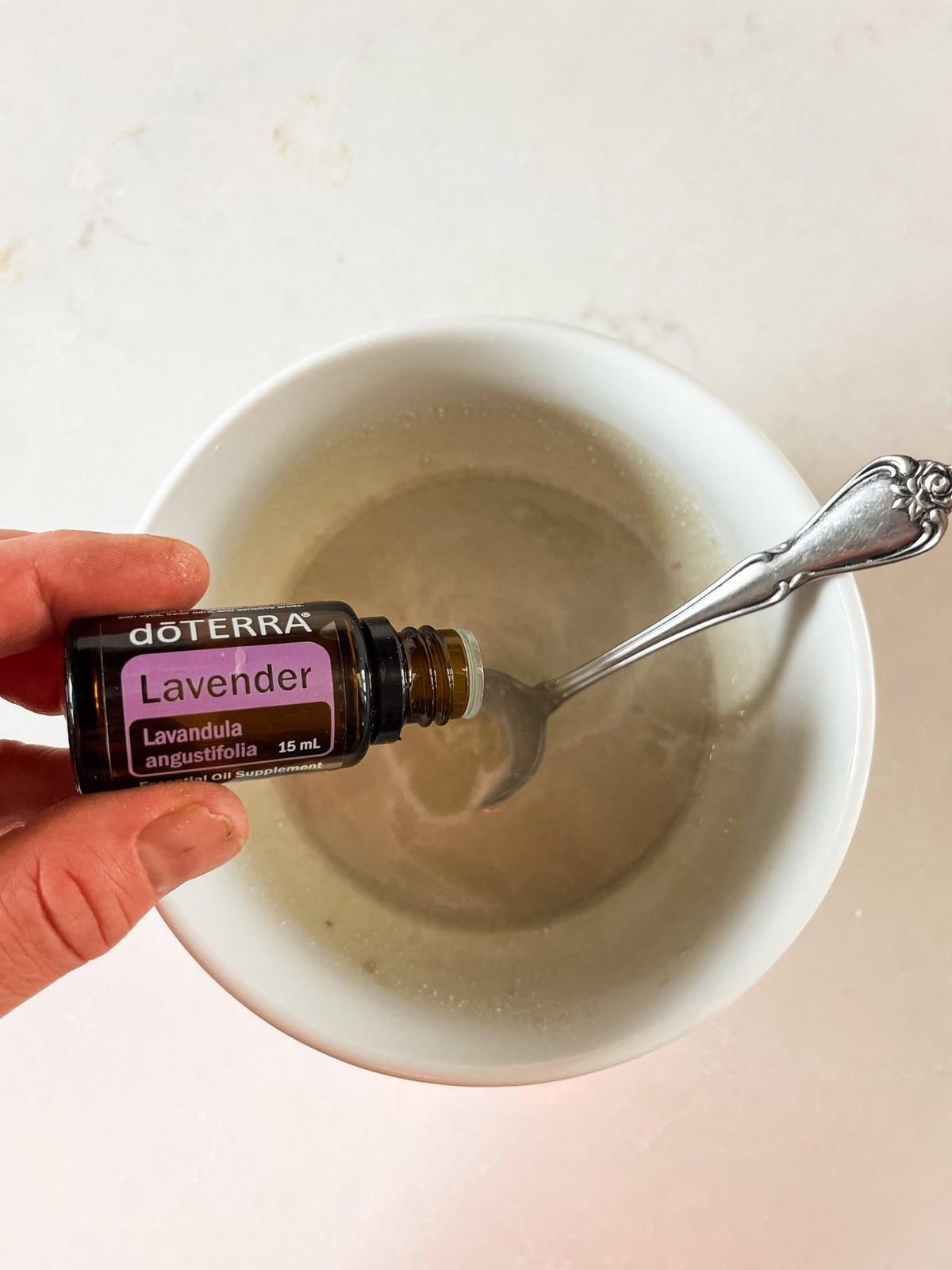 Dropping lavender essential oil into melted diaper cream ingredients. 