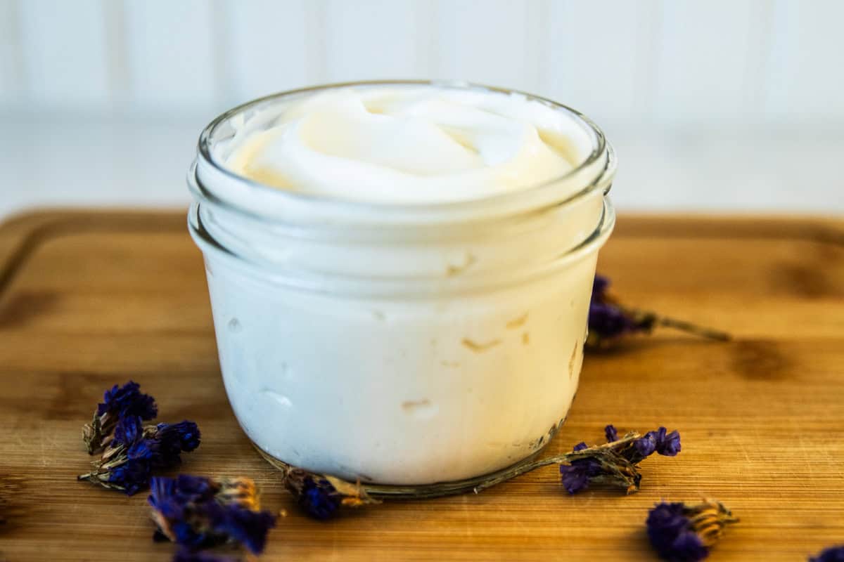 A glass jar filled with homemade tallow lotion.