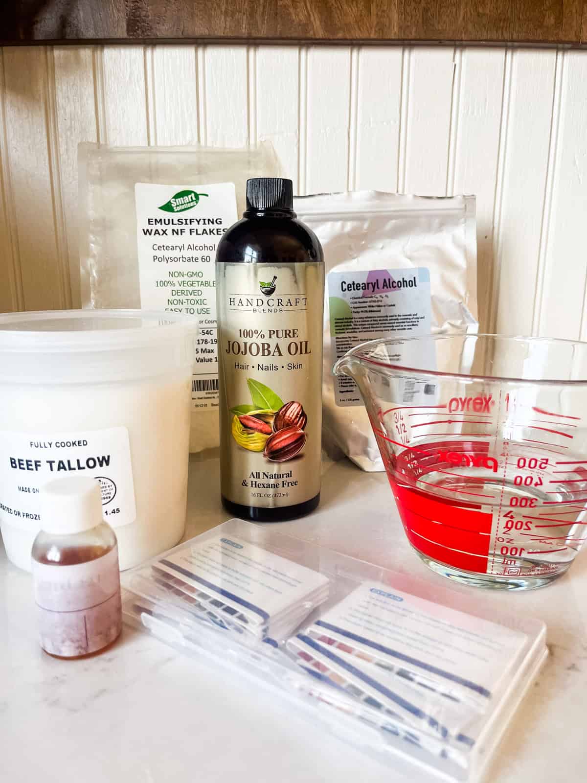 Homemade tallow lotion ingredients on a kitchen counter.