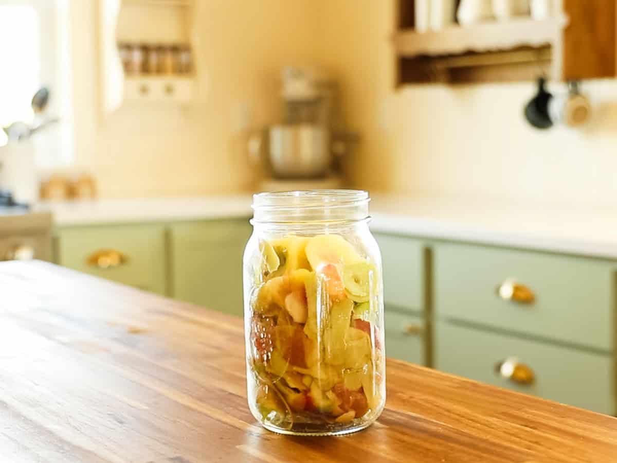 Apple scraps in a mason jar on a kitchen table.