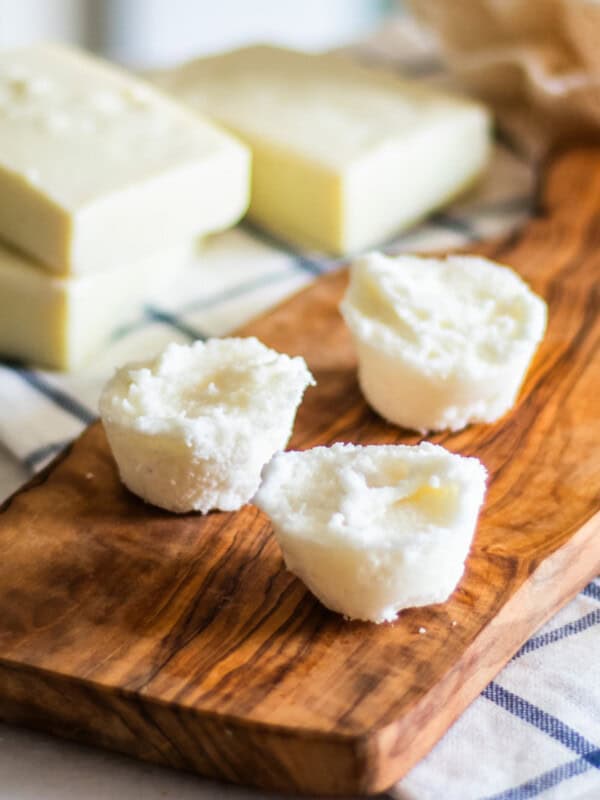 Three DIY bubble bath bars on a wooden board.