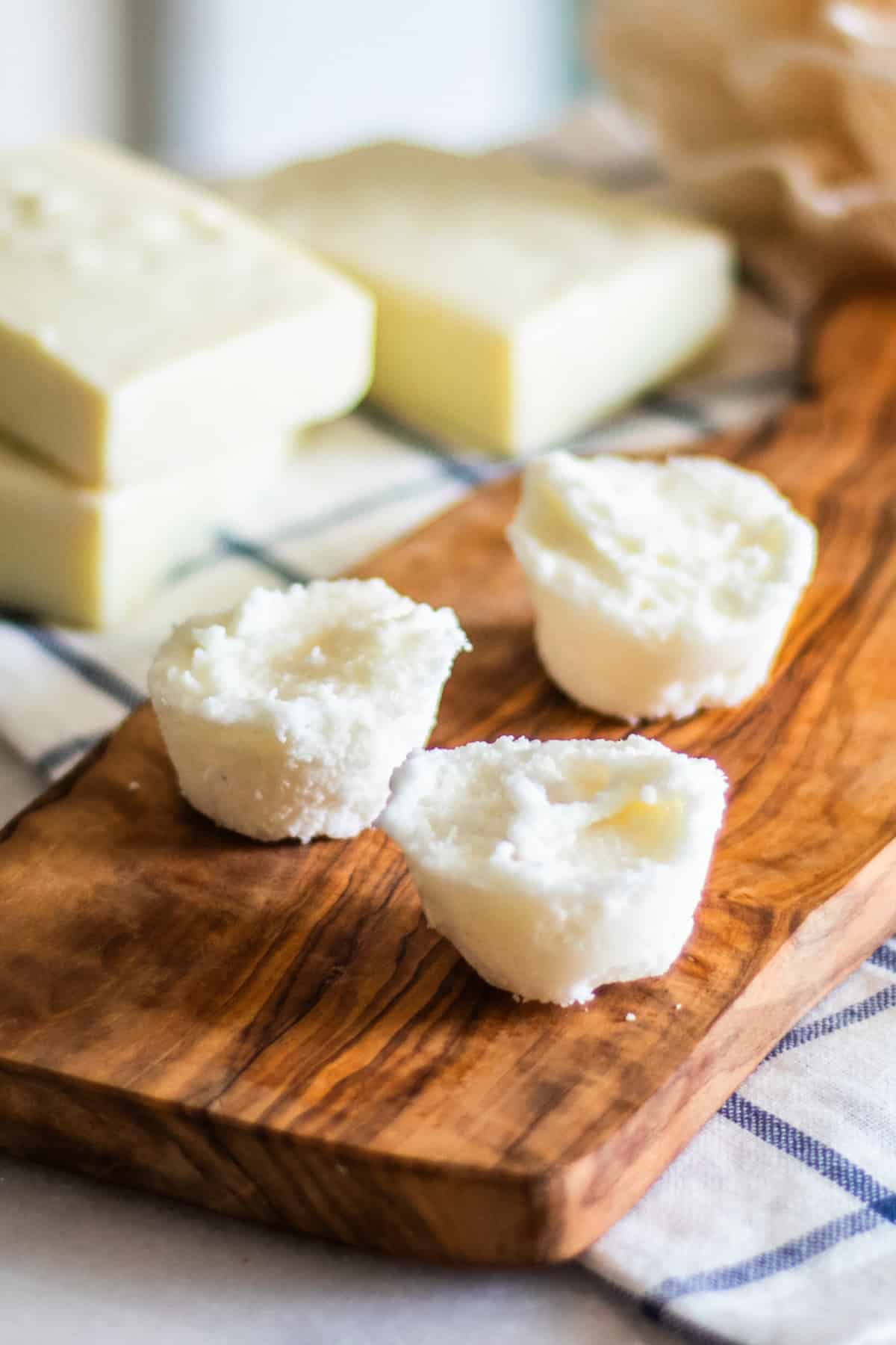 Three DIY bubble bath bars on a wooden board. 
