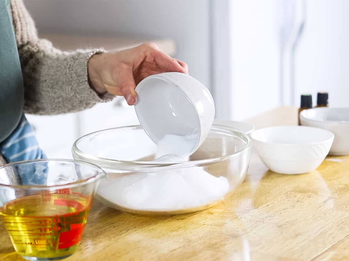 Pouring dry ingredients into a glass bowl.