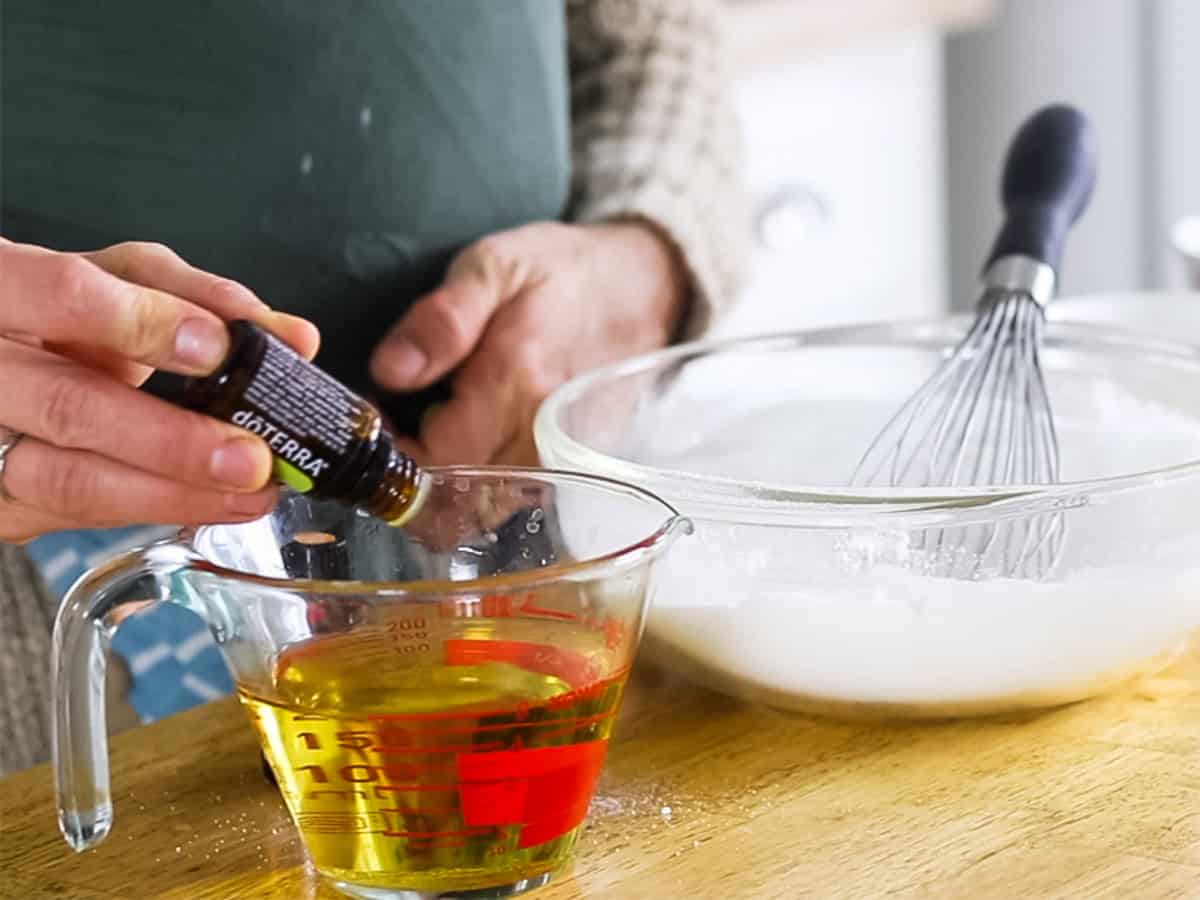 Adding essential oils to liquid ingredients in a glass measuring cup.