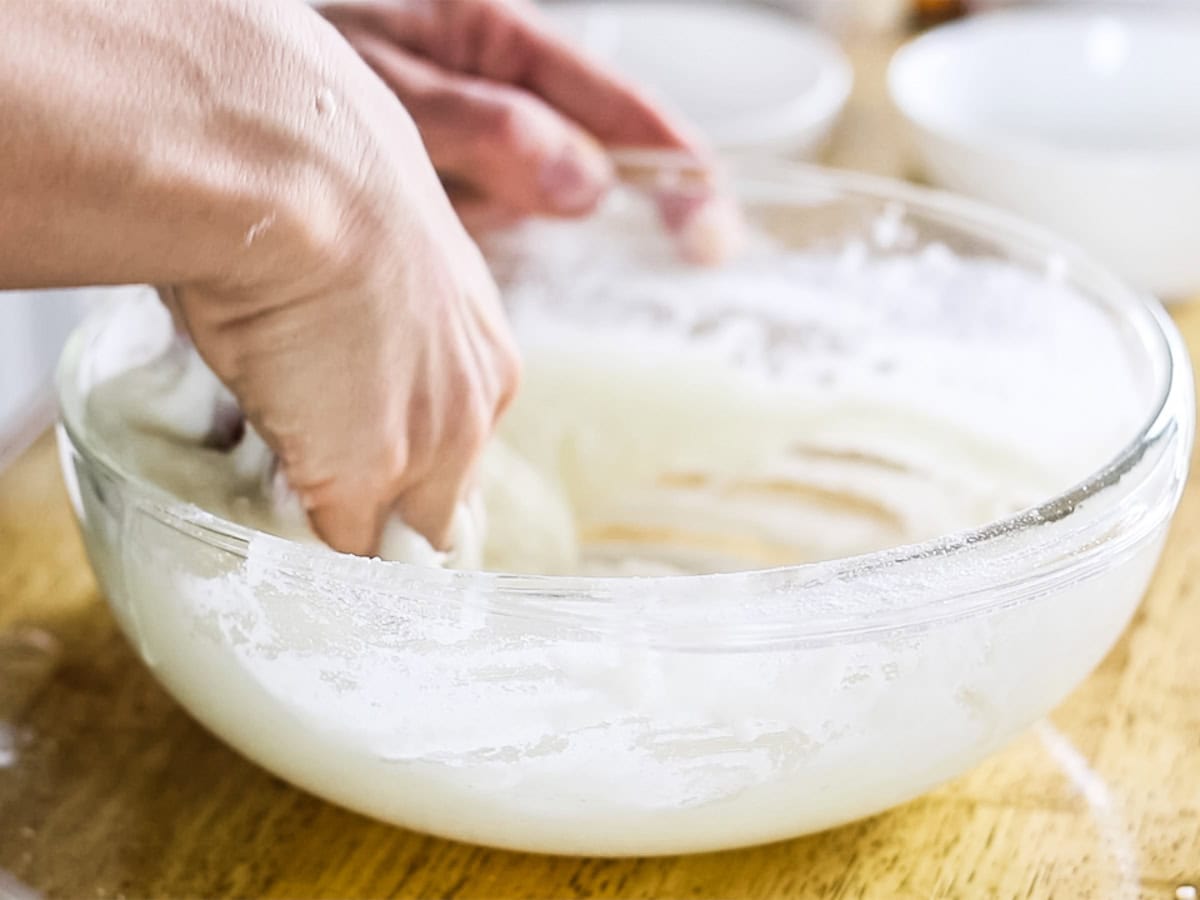 Stirring bubble bath bar ingredients in a bowl with my hands.