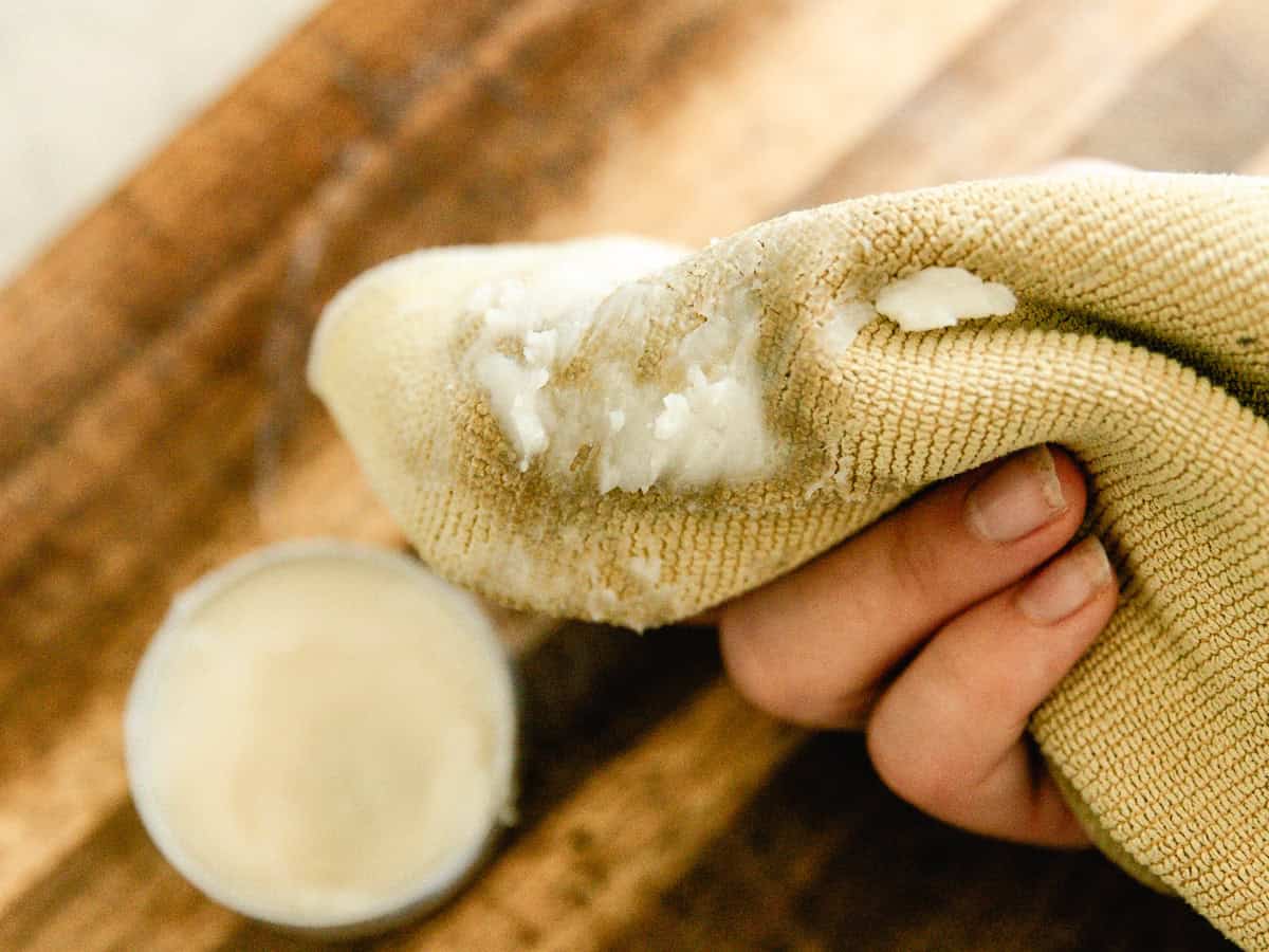 Holding a rag with a glob of wood balm on it.