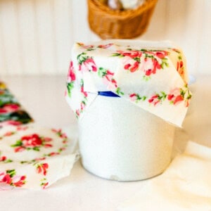 A homemade beeswax wrap covering a crock in a kitchen.