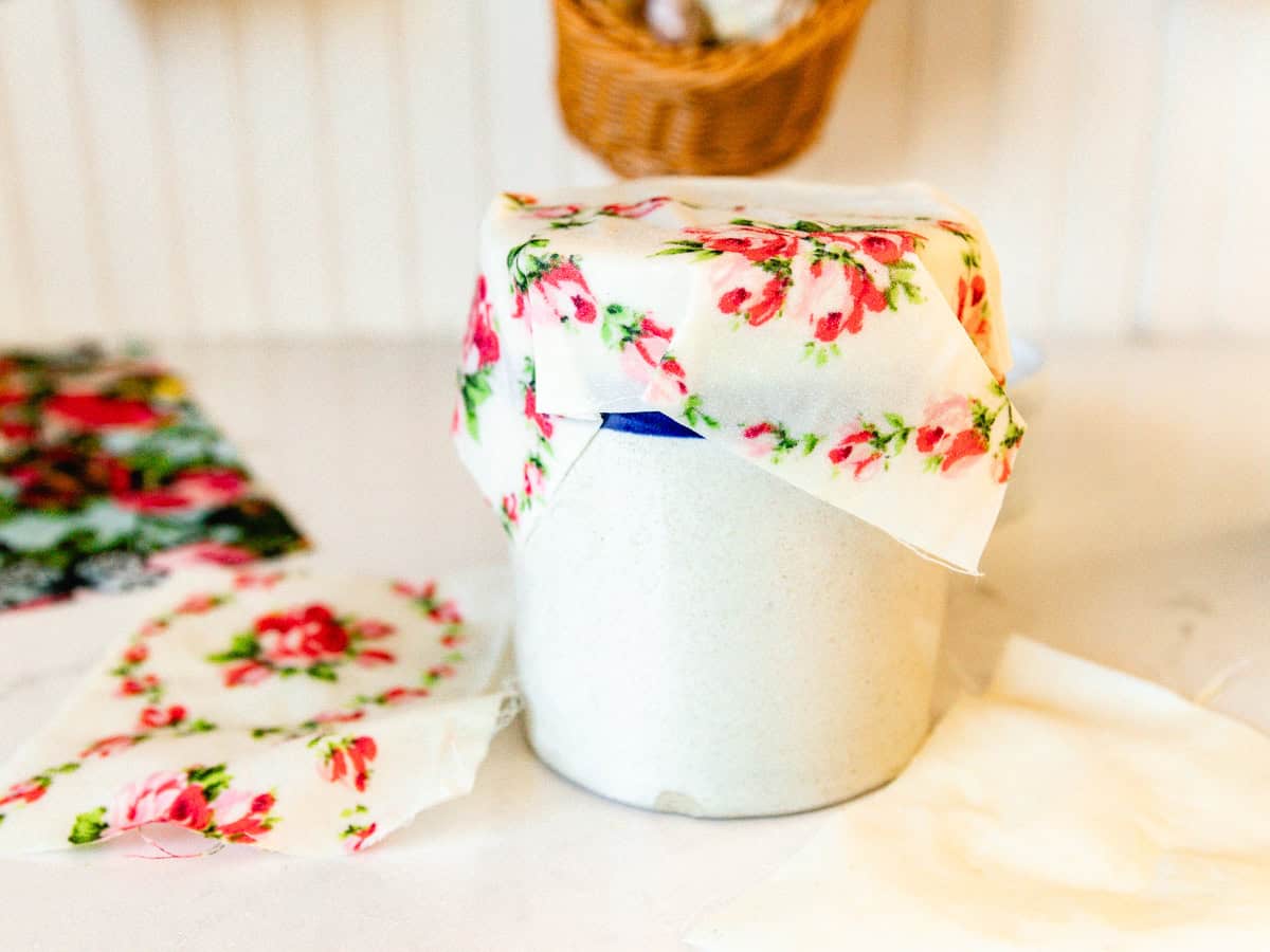 A homemade beeswax wrap covering a crock in a kitchen. 