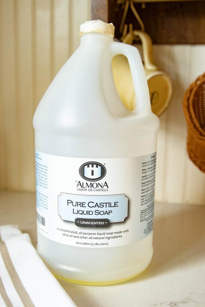 A gallon jug of castile soap on a kitchen counter.