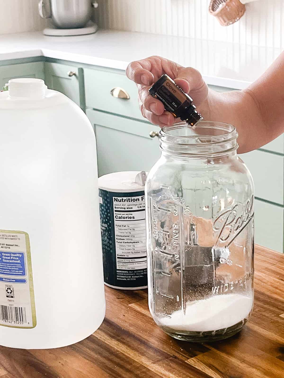 Dropping essential oils into a jar of salt. 