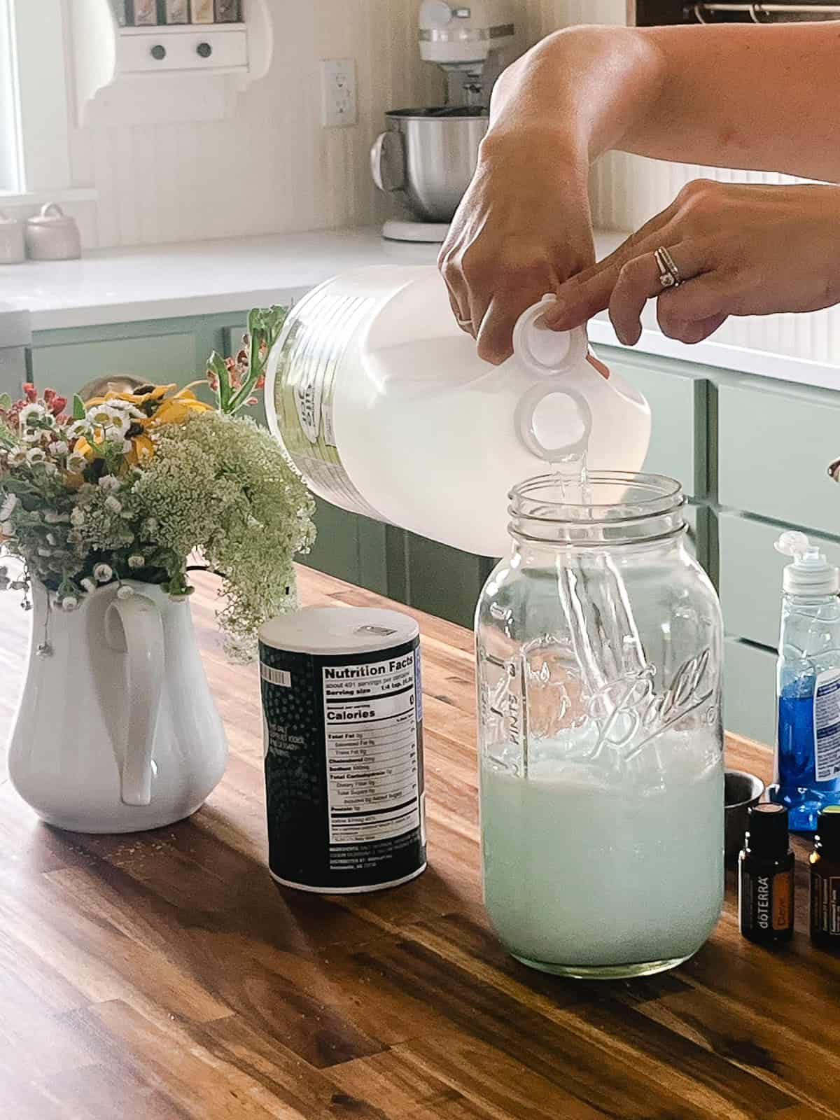 Pouring vinegar into a jar to make natural weed killer.