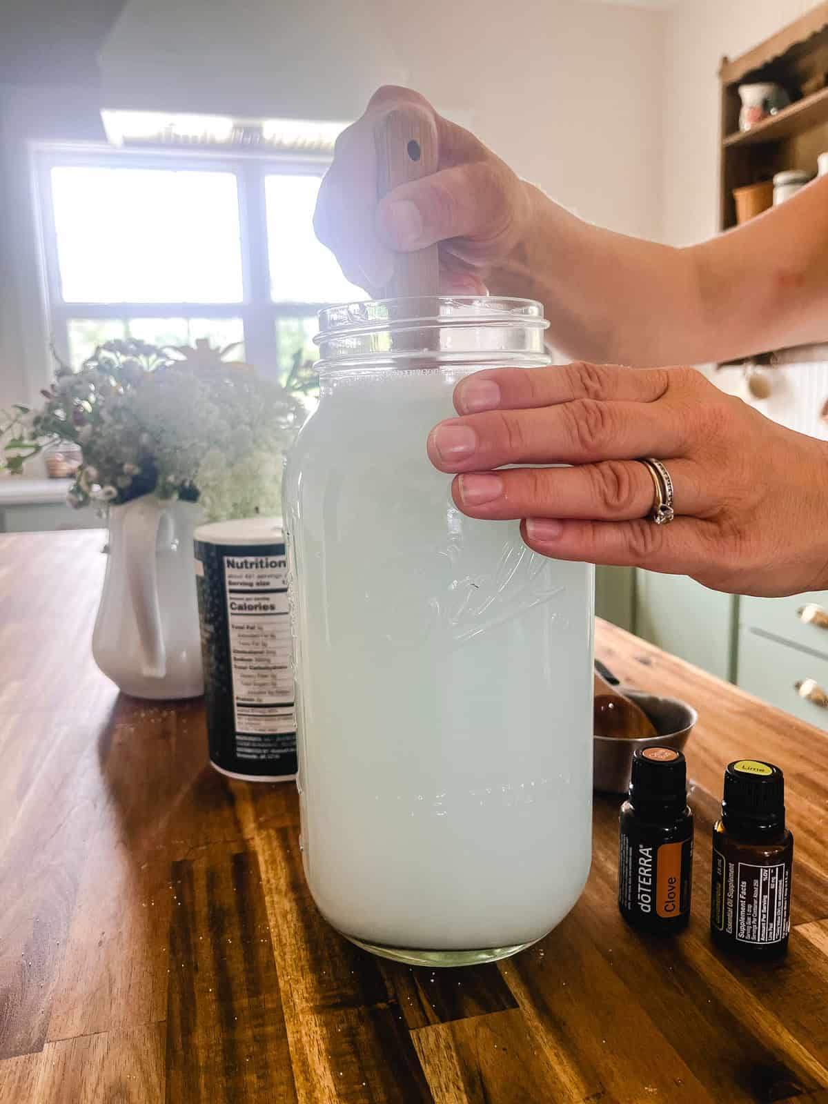 Stirring a jar of natural weed killer with a spoon.