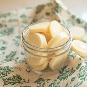 A jar of homemade wax melts on a green towel.