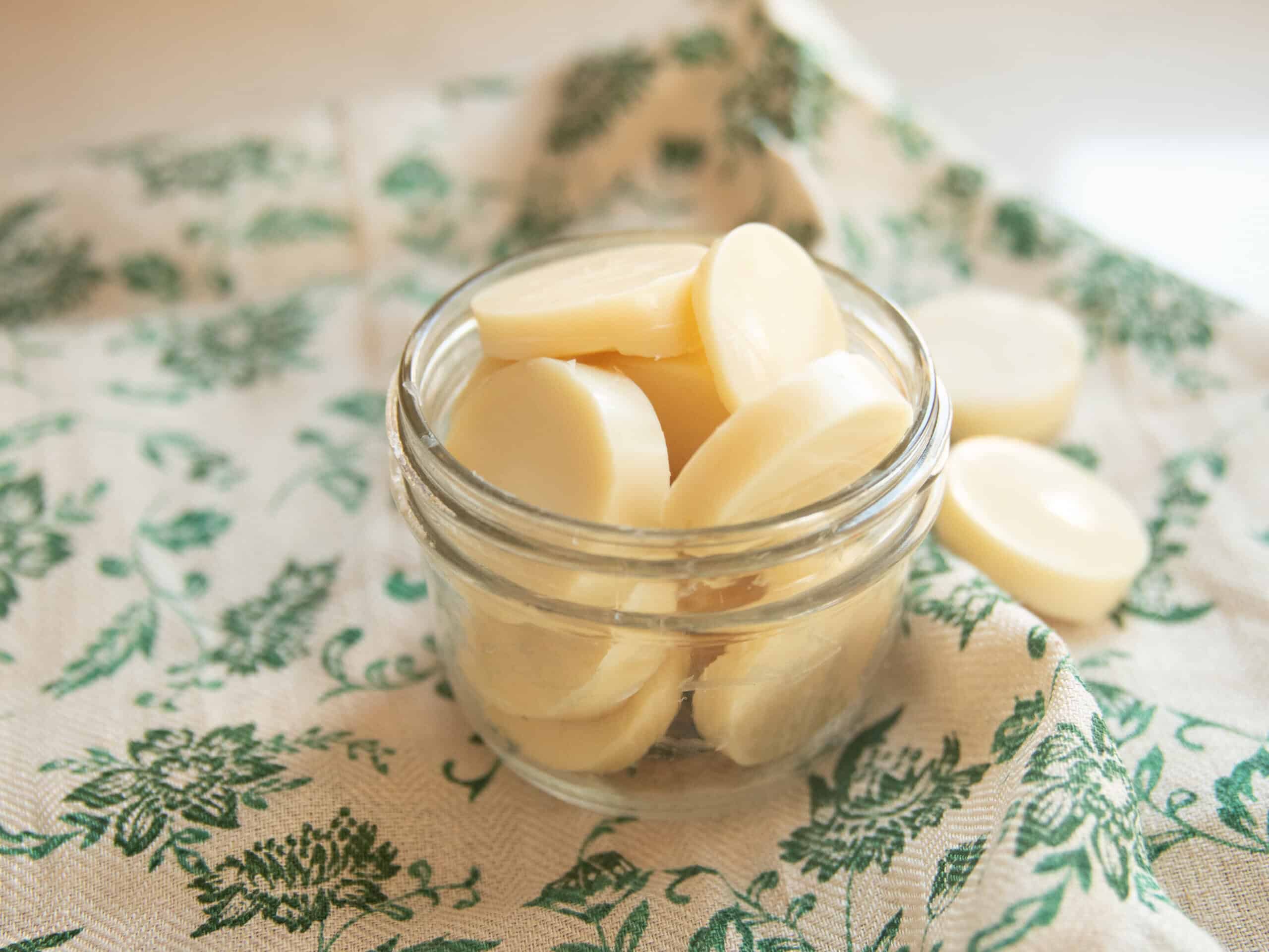 A jar of homemade wax melts on a green towel.