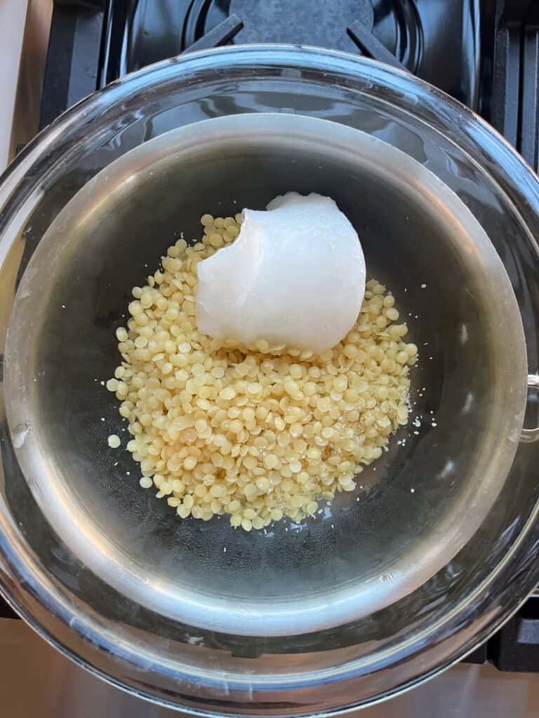 Melting beeswax and coconut oil in a double boiler.