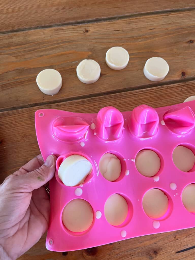 Removing hardened wax melts from a silicone mold.