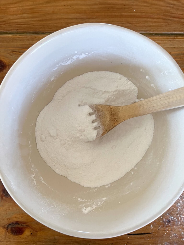 Stirring dry ingredients together with a wooden spoon. 